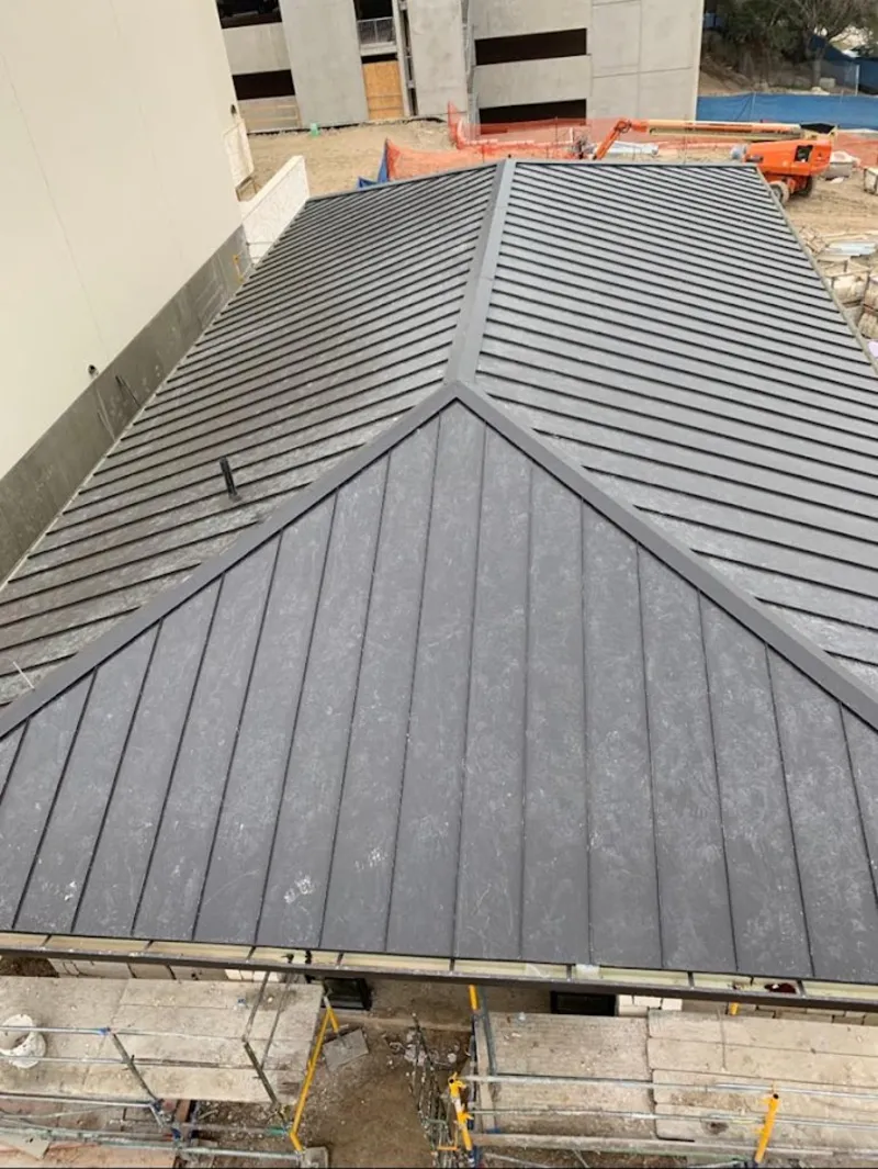 Commercial metal roof construction with crane equipment in Essex